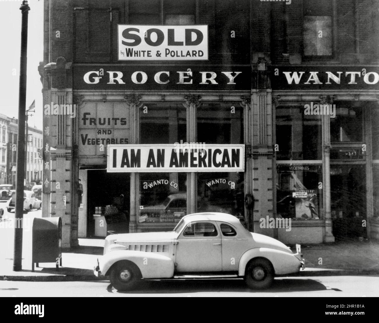 Dorothea Lange - I Am An American signage on front of Japanese-American store during aftermath of Pearl Harbor attack - 1942 Stock Photo