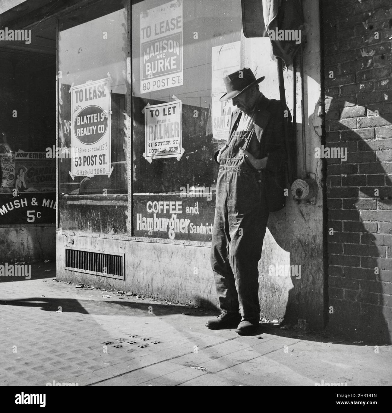 Dorothea Lange - Unemployed, Destitute Man Leaning Against Vacant Store - 'Skid Row.' Howard Street, San Francisco, California, February 1937 Stock Photo