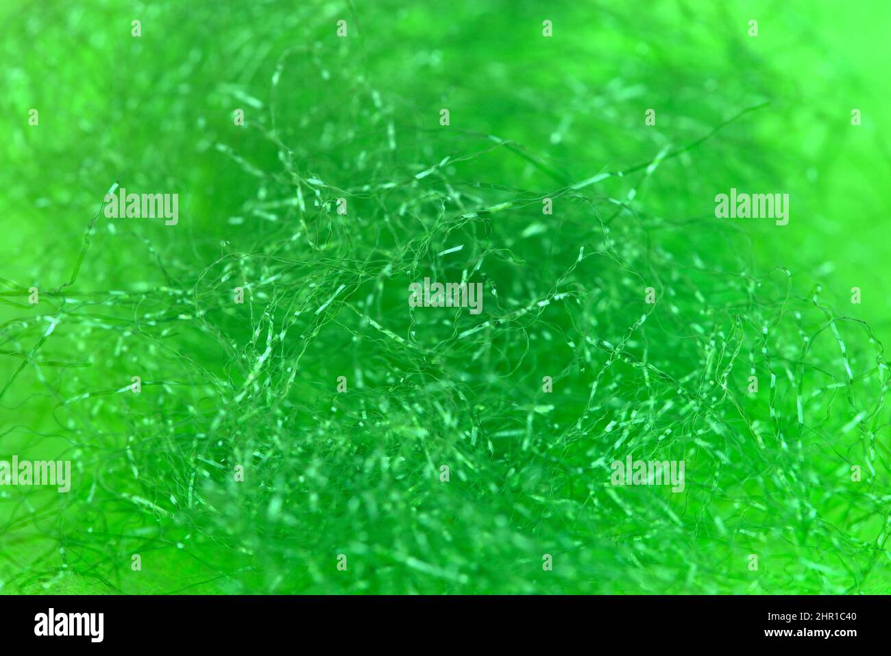 tangled shiny green synthetic fiber background in macro shot Stock Photo