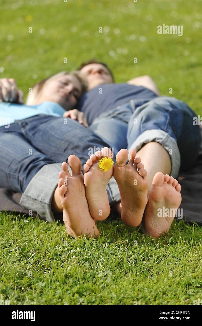 couple in love lying barefoot in a meadow Stock Photo