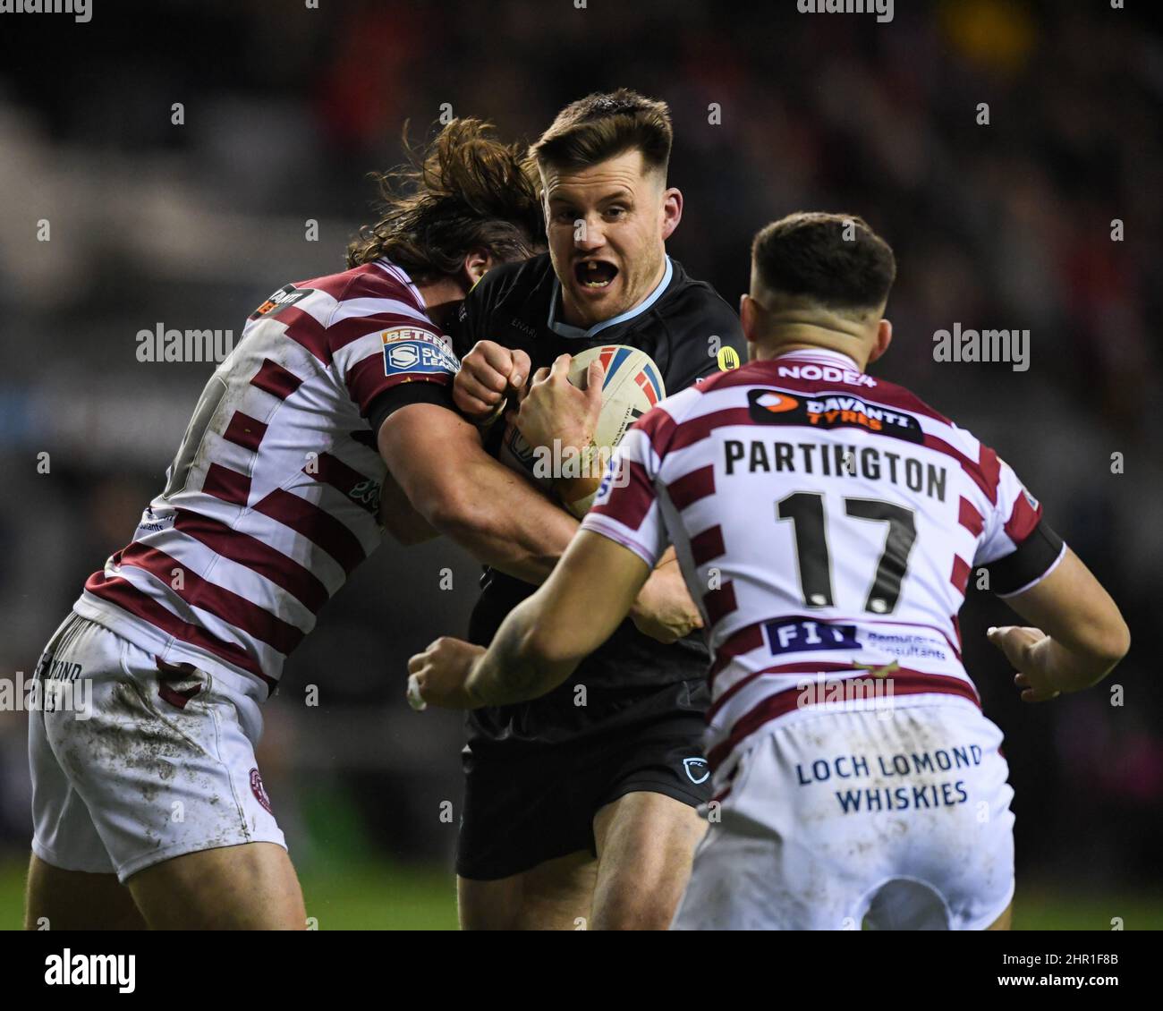Wigan, UK. 24th Feb, 2022. Joe Greenwood #15 of Huddersfield Giants looks for a way past Liam Byrne #20 and Oliver Partington #17 of Wigan Warriors in Wigan, United Kingdom on 2/24/2022. (Photo by SW Photo via/News Images/Sipa USA) Credit: Sipa USA/Alamy Live News Stock Photo