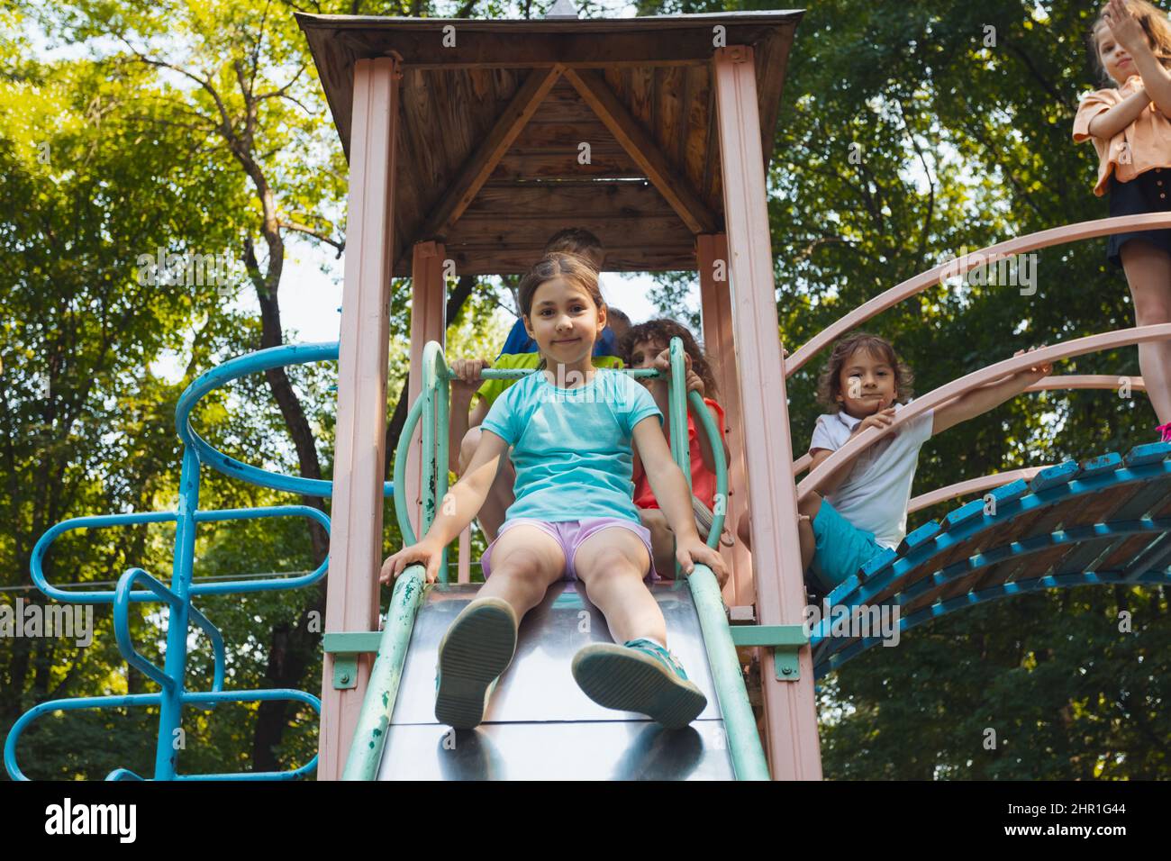 The little girl is sitting on a slide in the playground Stock Photo - Alamy