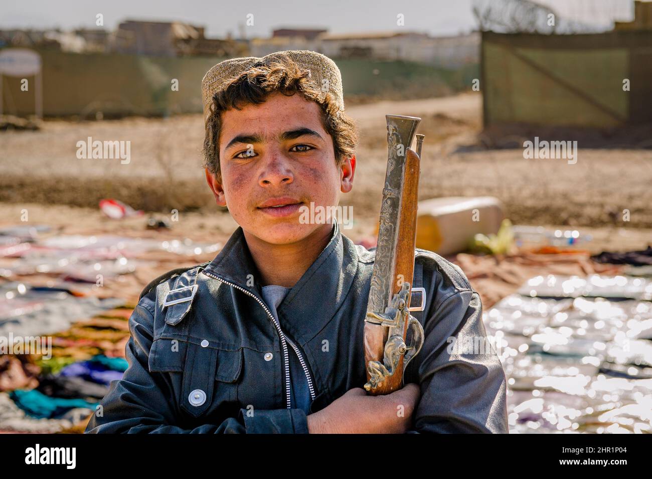 A young boy holding an old gun at an Afghan market in Tarin Kot
