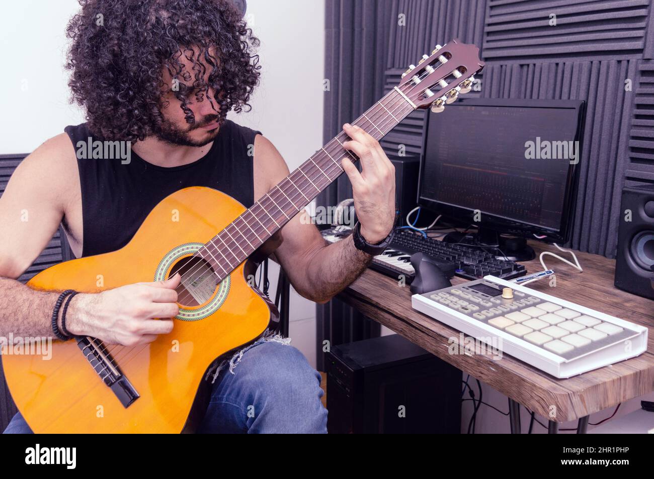 Caucasian male guitar teacher in his home studio giving lessons via
