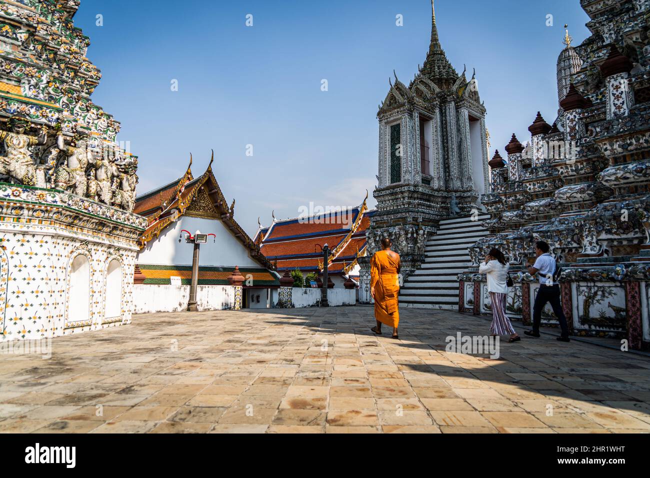Bangkok, Thailand. 25th Feb, 2022. A monk seen guiding tourists through Wat Arun in Bangkok. Daily life around Bangkok as Thailand prepares to relax requirements for the 'Test and Go' program, its quarantine-free entry scheme for fully-vaccinated international tourists. The easing of entry requirements comes as the country is experiencing a surge in COVID-19 infections, averaging over 20,000 reported cases per day. Credit: SOPA Images Limited/Alamy Live News Stock Photo