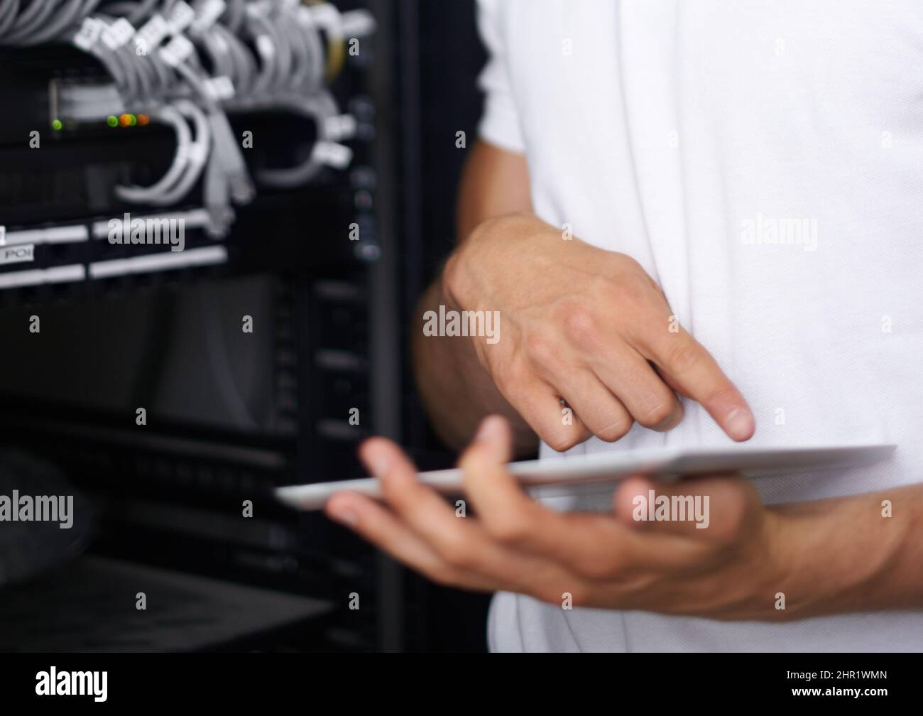 Getting you back online. A computer technician browsing the internet on his digital tablet. Stock Photo