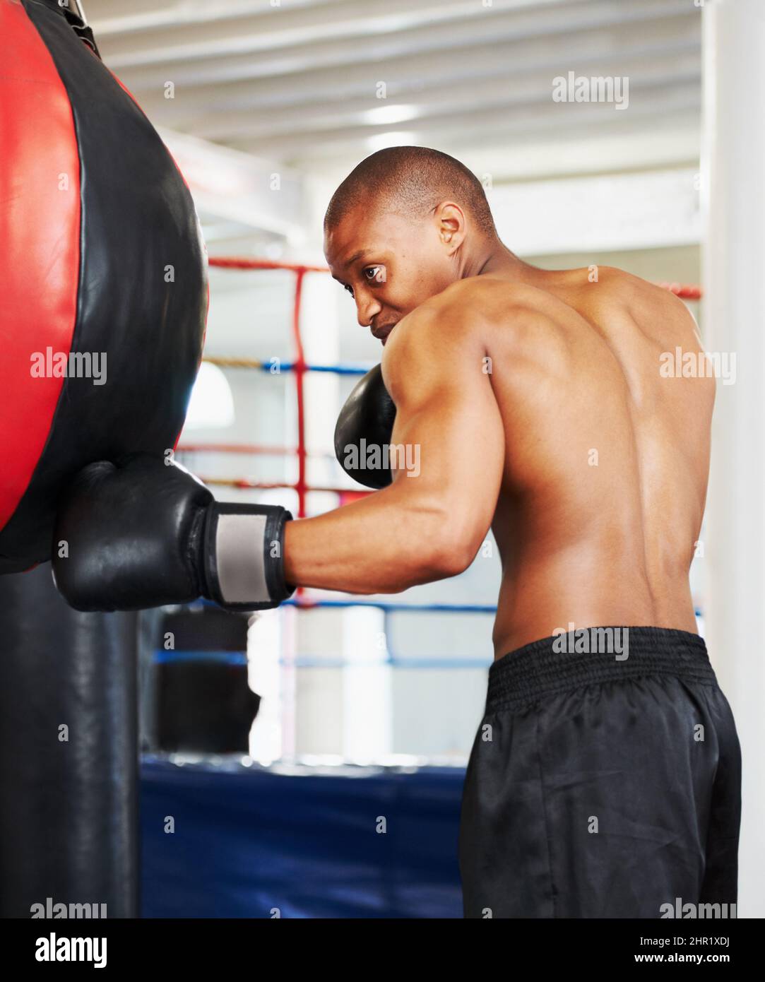 Refining his technique. An african american boxer practicing with a punching ball. Stock Photo