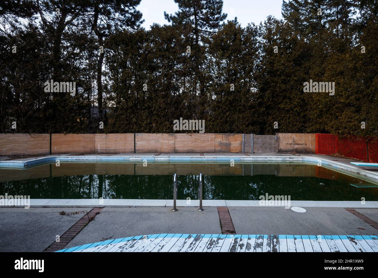 A dirty swimming pool filled with water. This house has been demolished. Stock Photo