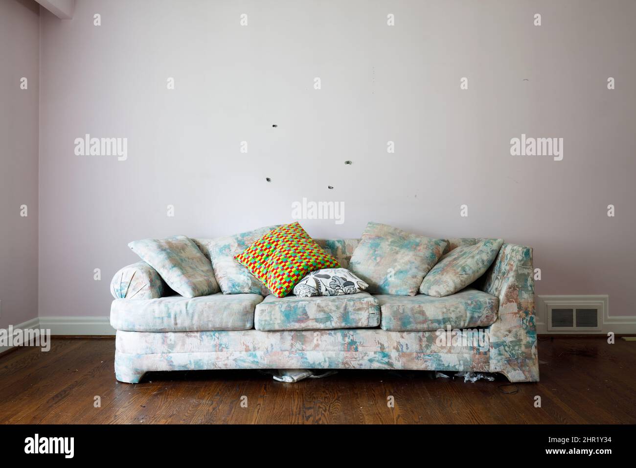 An ugly couch inside an otherwise empty room.  This house has been demolished. Stock Photo