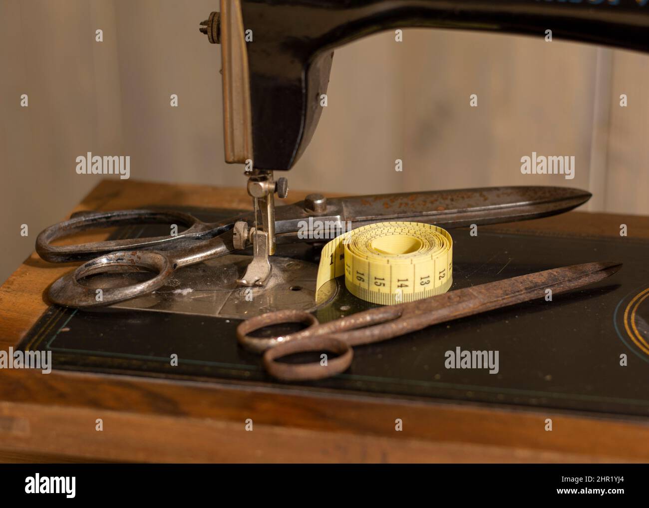https://c8.alamy.com/comp/2HR1YJ4/old-vintage-sewing-machine-with-an-old-rusty-pair-of-scissors-and-a-tape-measure-sewing-tailor-cloth-ruler-2HR1YJ4.jpg