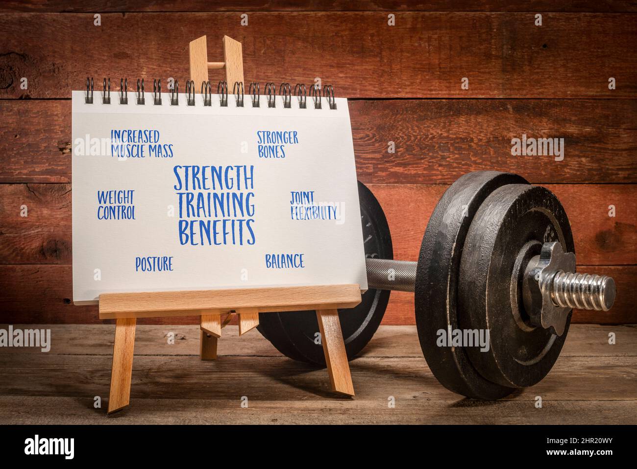 benefits of strength training infographics - easel sign with notebook and heavy dumbbell Stock Photo