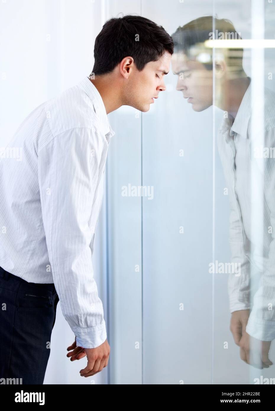 Banging my head against a glass door. A young businessman hitting his