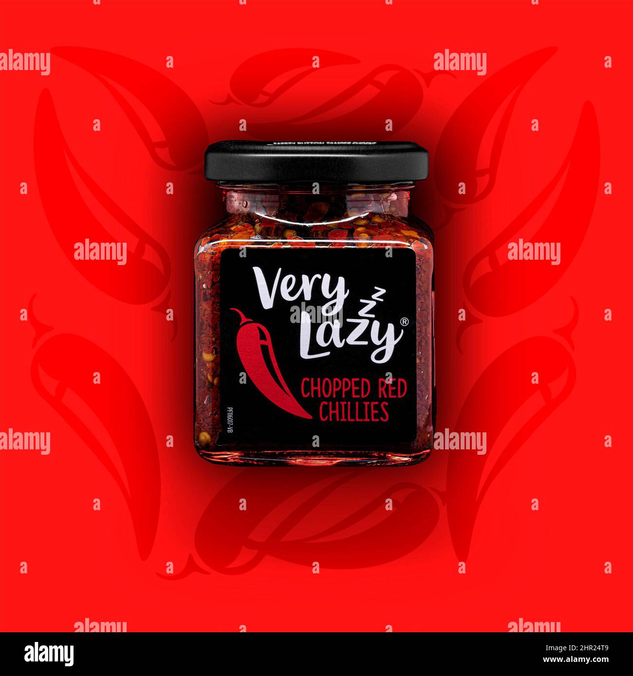 SWINDON, UK - Febuary 25 2022: Jar of Very Lazy Chopped Red Chillies on a red chillie background Stock Photo