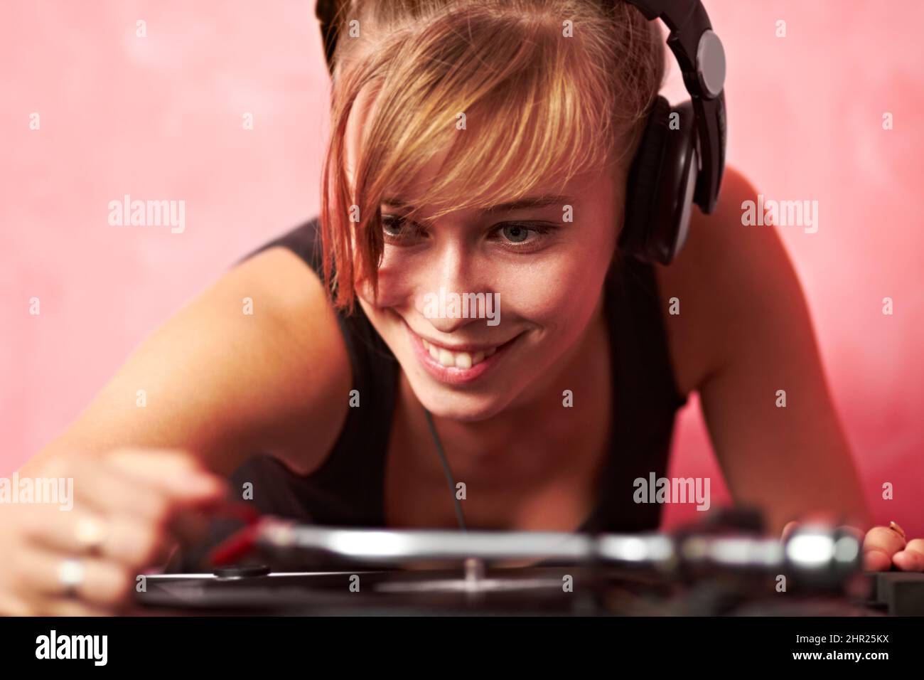 Living the dream. Closeup of a young female dj putting a record on the turntable. Stock Photo