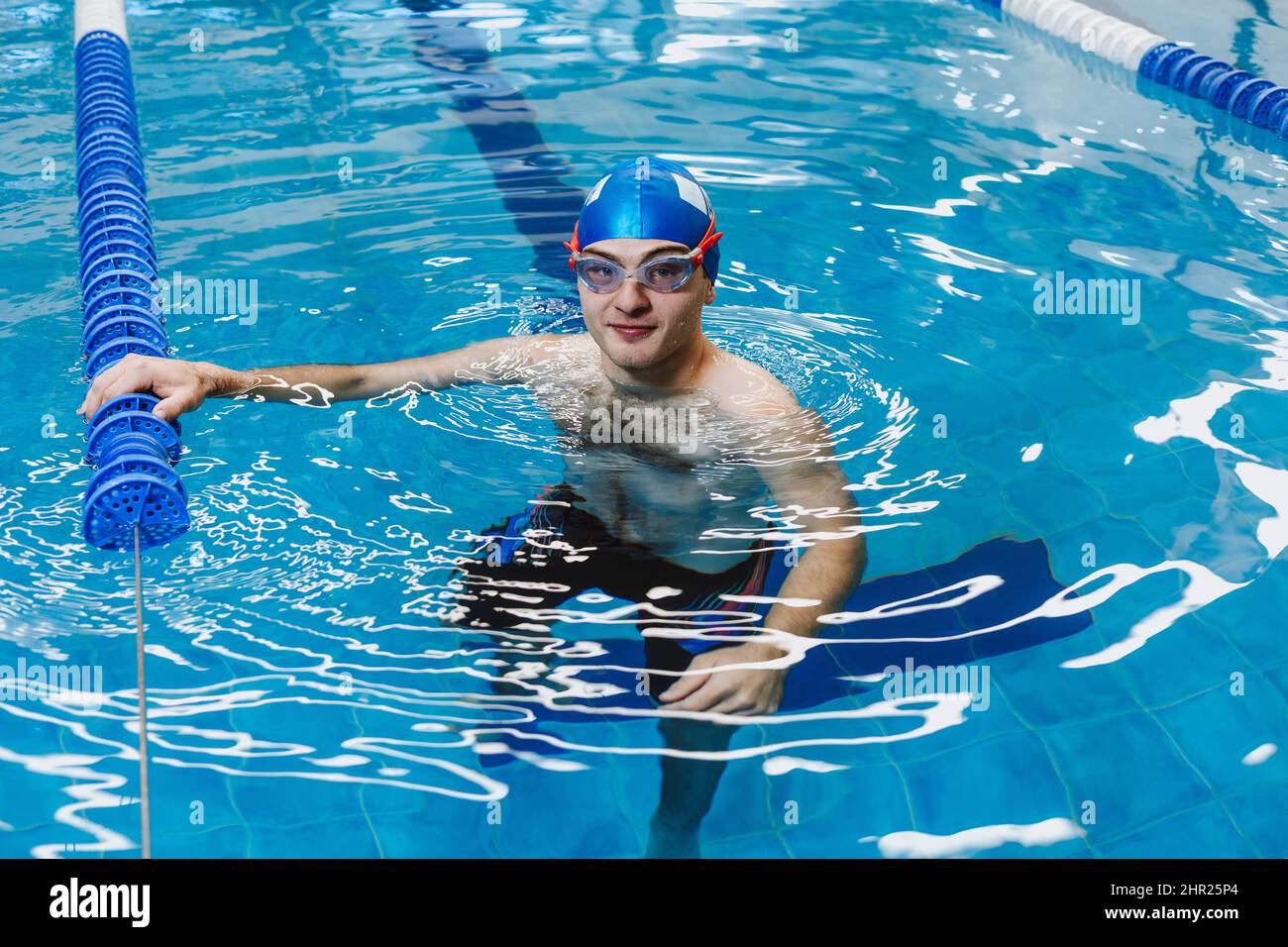 latin young man teenager swimmer athlete wearing cap and goggles in a swimming training in the Pool in Mexico Latin America Stock Photo