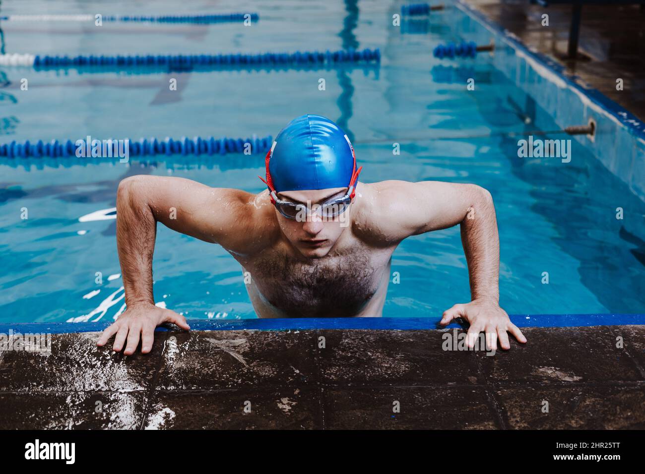 latin young man teenager swimmer athlete wearing cap and goggles in a swimming training in the Pool in Mexico Latin America Stock Photo