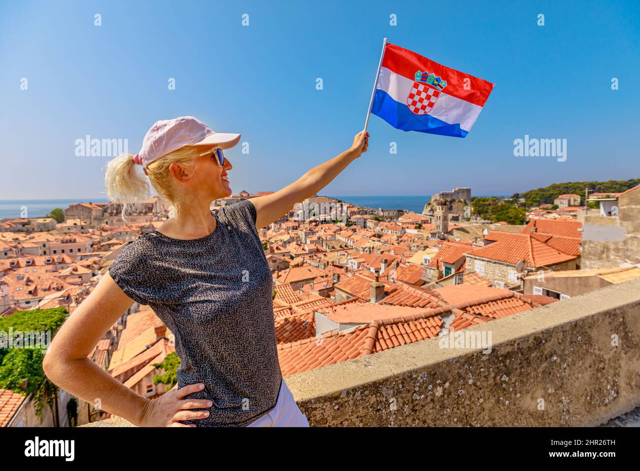 Woman with Croatian flag on Dubrovnik walls of Croatia. View of Fort Lovrijenac fortress Dubrovnik UNESCO Venetian town of Croatia in Dalmatia Stock Photo