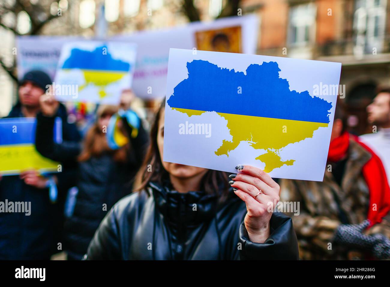 A protester holds a placard with a map of Ukraine painted in ukrainian natonial colours - blue and yellow.  Following the beginning of the Russian inv Stock Photo