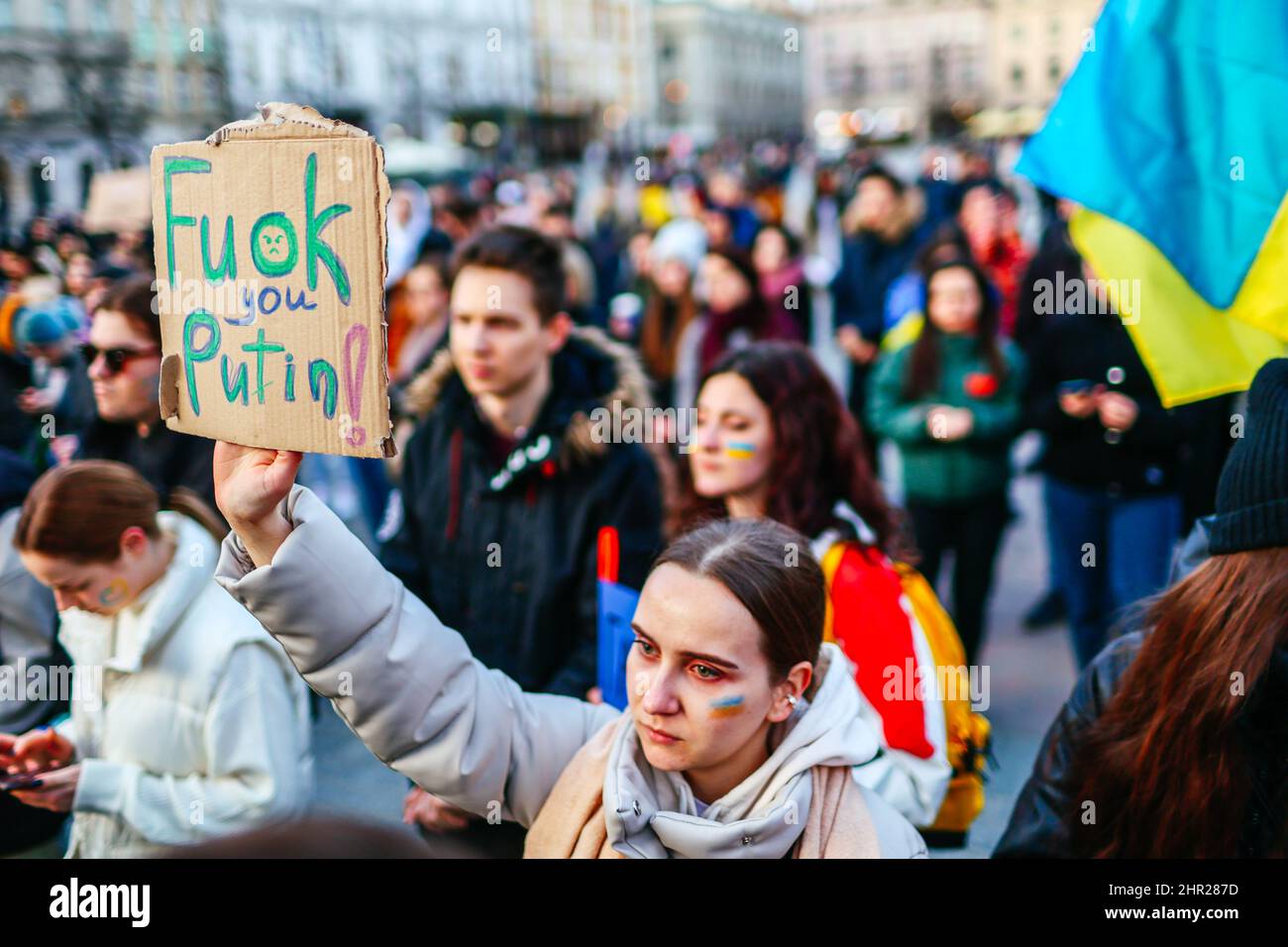A protester with an Ukrainian flag painted on her cheek holds a placard that reads 'F..ck you Putin'.  Following the beginning of the Russian invasion Stock Photo