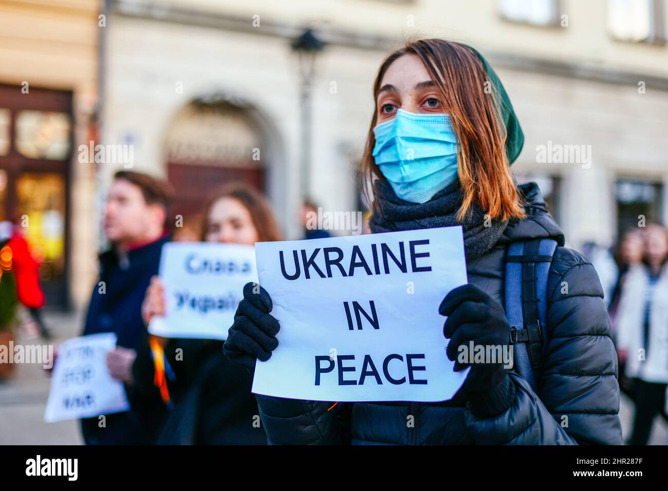 A protester wearing a facemask holds a banner that reads 'Ukraine in peace'.  Following the beginning of the Russian invasion of Ukraine, members of t Stock Photo