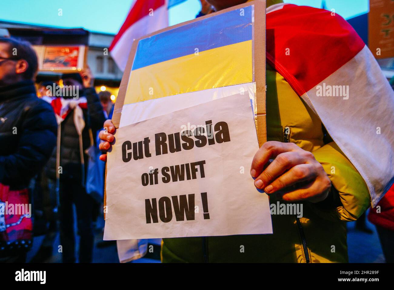 A member of Belarusian community holds a placard with Ukrainian flag and an inscription 'Cut Russia off SWIFT now!'.  Following the beginning of the R Stock Photo