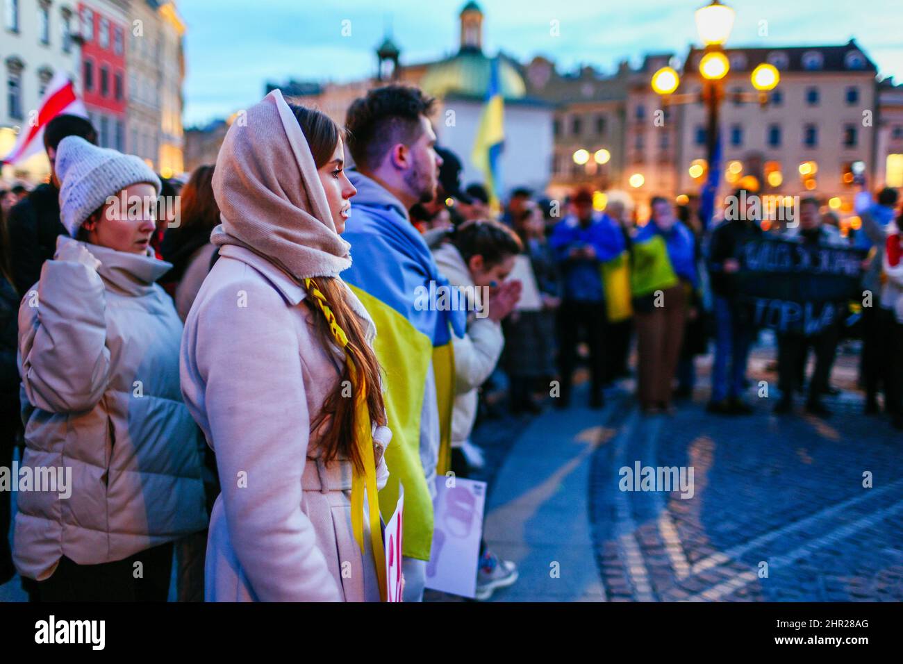 Member of Ukrainian community stand up straight while singing Ukrainian national anthem during the anti-war protest.  Following the beginning of the R Stock Photo
