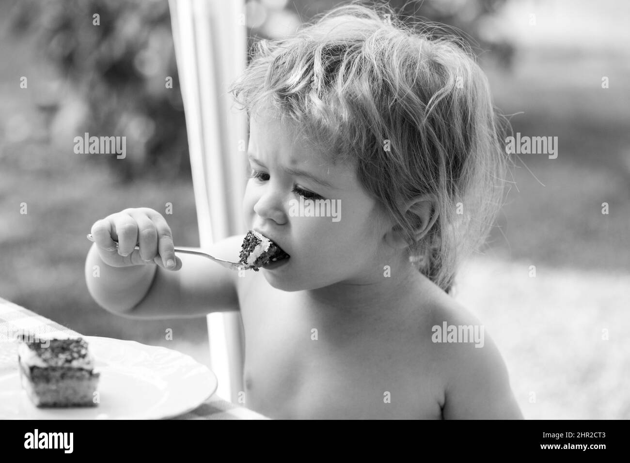 Baby eating cake. Funny cute little boy eat sweet cake. Child eating