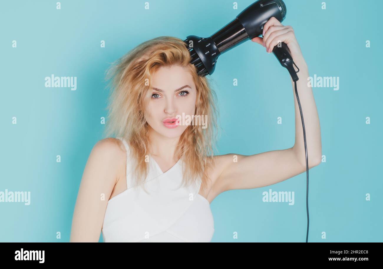 Woman blow drying her hair. Young girl with drying hair with hair dry