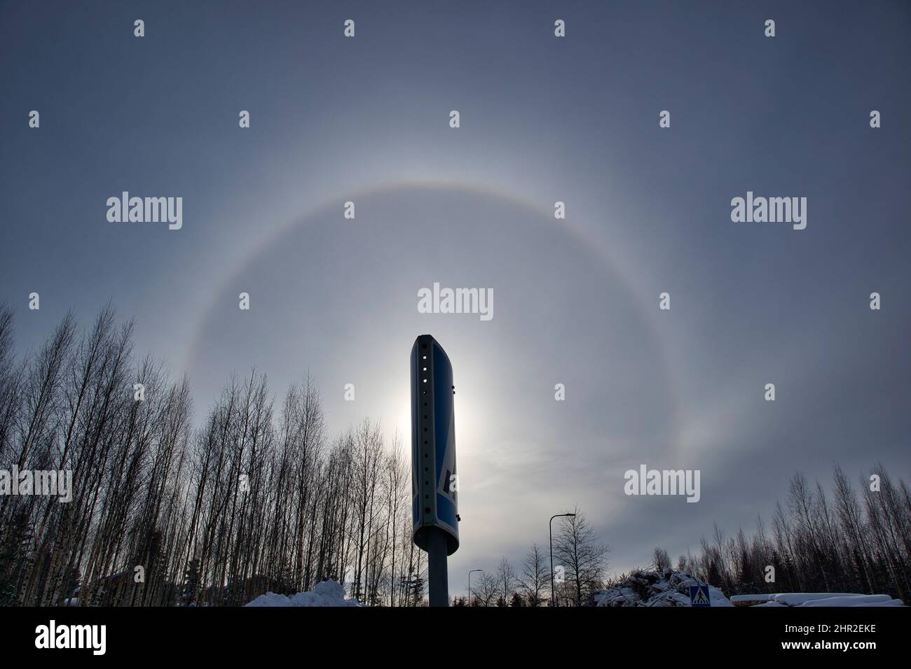 sun halo with circular rainbow in winter sky Stock Photo
