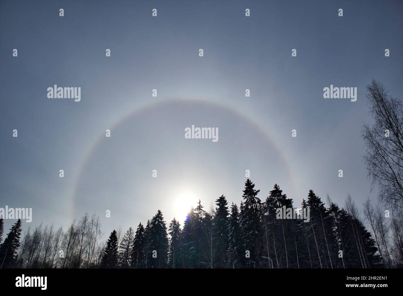 sun halo with circular rainbow in winter sky Stock Photo