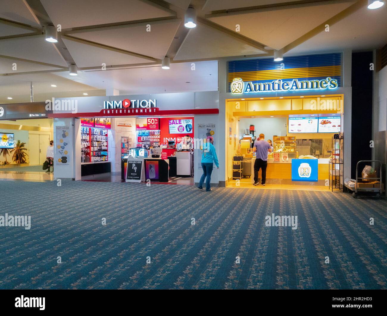 Orlando, Florida - February 4, 2022: Wide View of Auntie Anne's Shop and Inmotion Entertainment inside Terminal B of Orlando International Airport Stock Photo