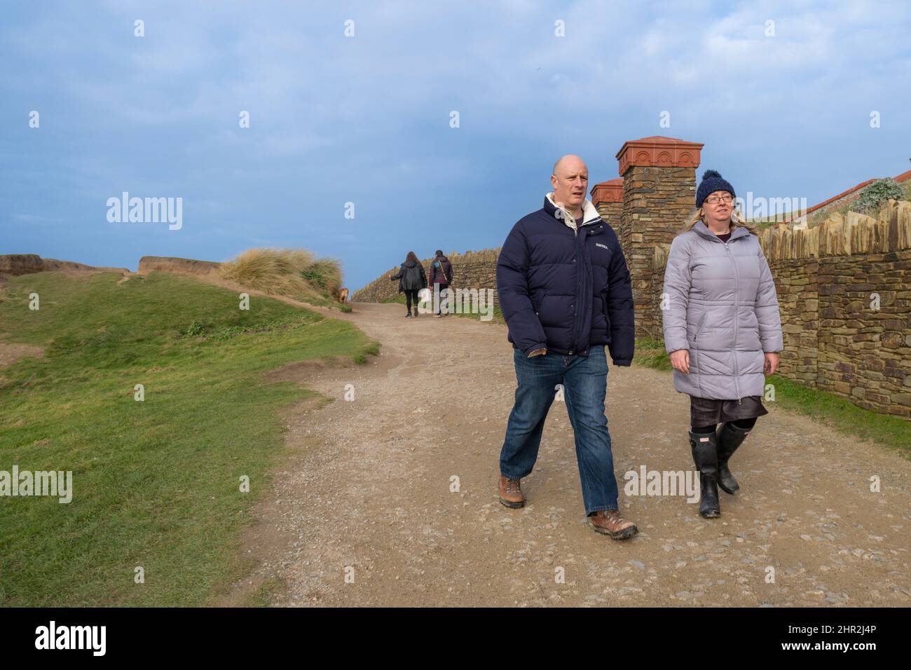 People enjoying a brisk walk along a footpath on the Headland in Newquay in Cornwall in the UK. Stock Photo
