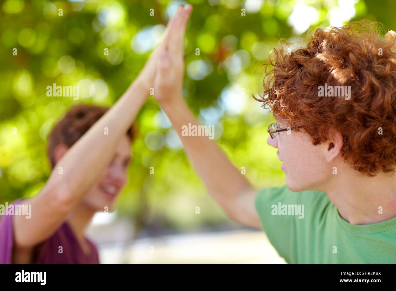Were awesome. Cropped shot of two teenagers giving each other a high-five. Stock Photo