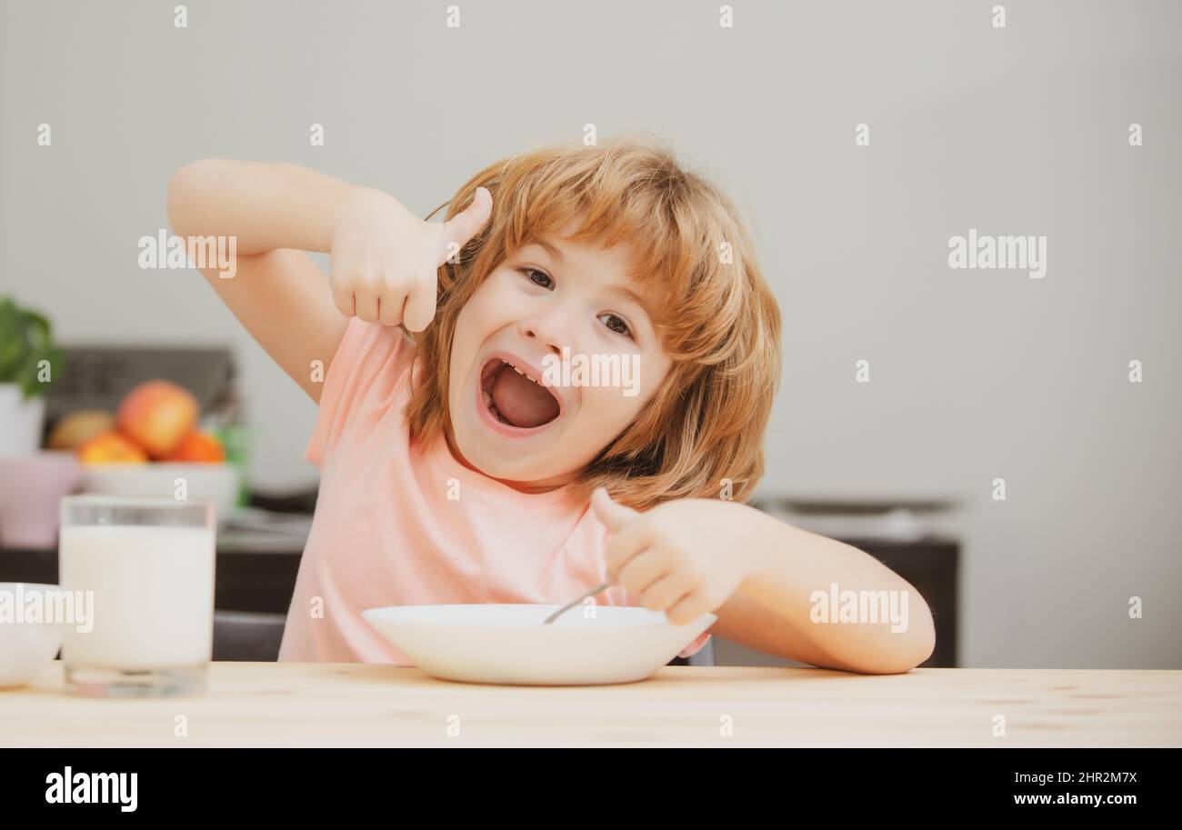 Healthy nutrition for kids. Caucasian toddler child boy eating healthy soup in the kitchen. Stock Photo