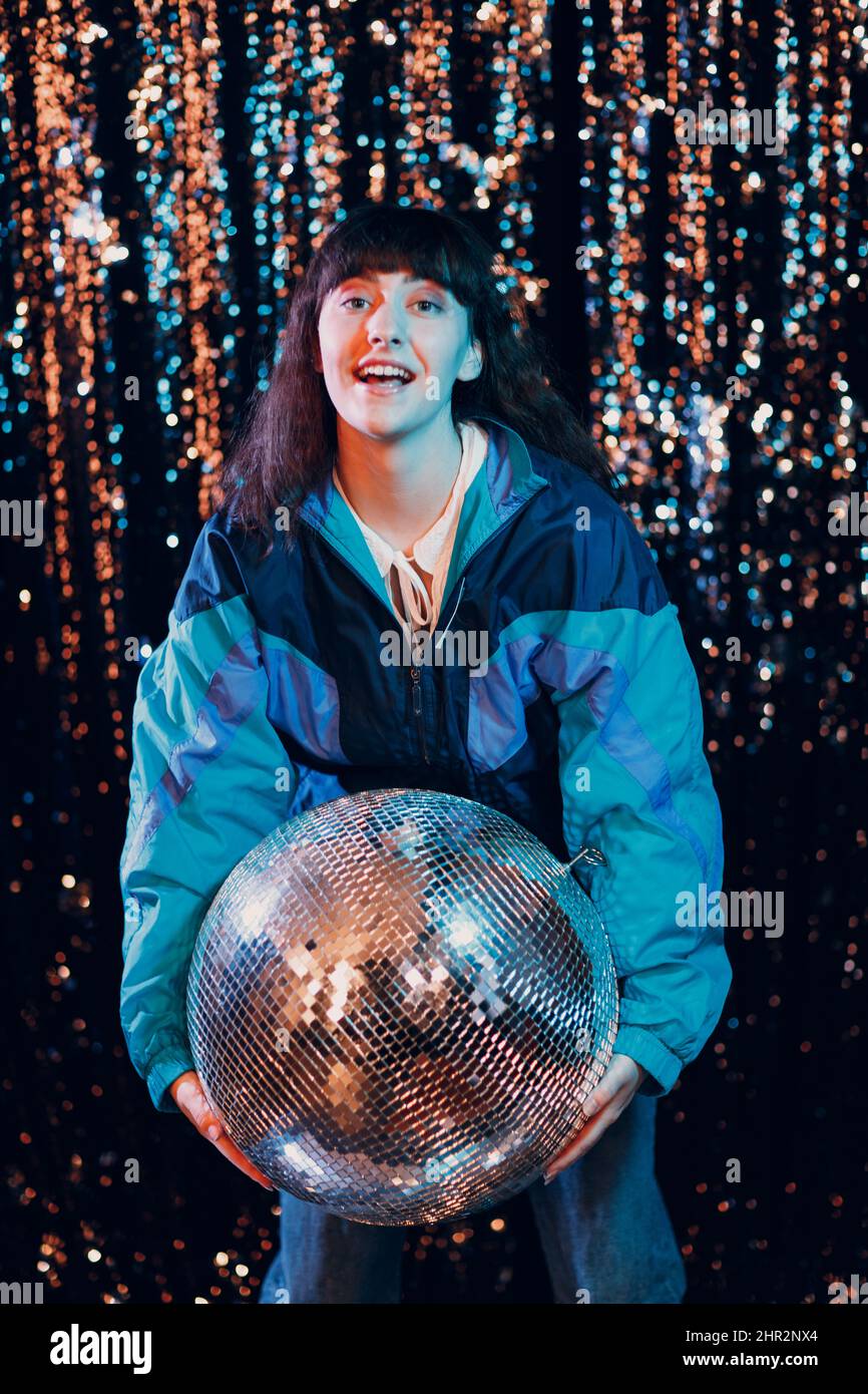 Young sporty woman 80 and 90's style. 90s fashion positive girl at night club disco party with disco ball Stock Photo
