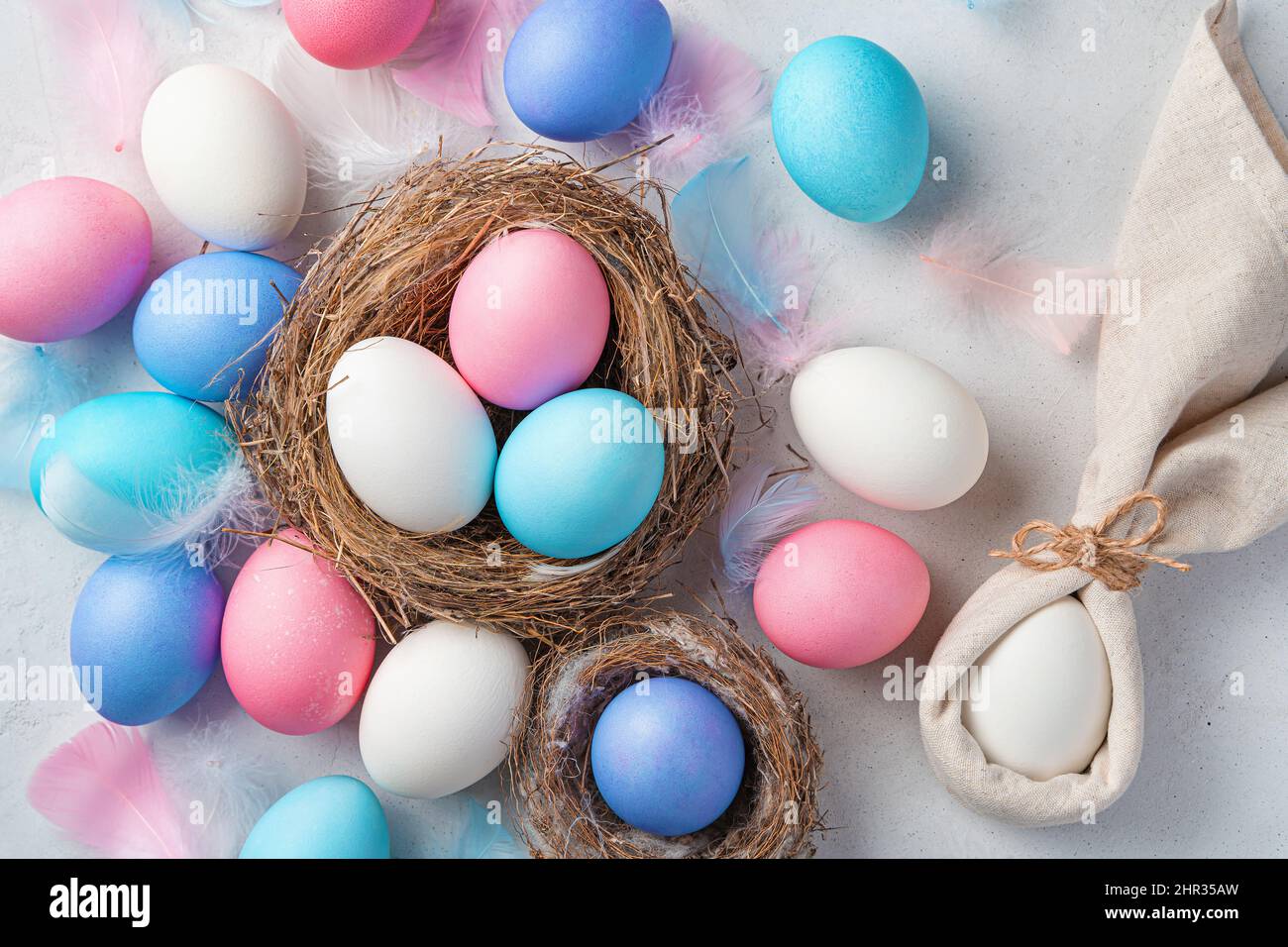 Festive background with Easter eggs and a rabbit on a gray background. Top view. Happy Easter. Stock Photo