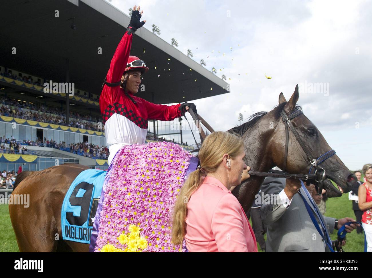 Jockey Luis Contreras throws flowers while being led to the winner's