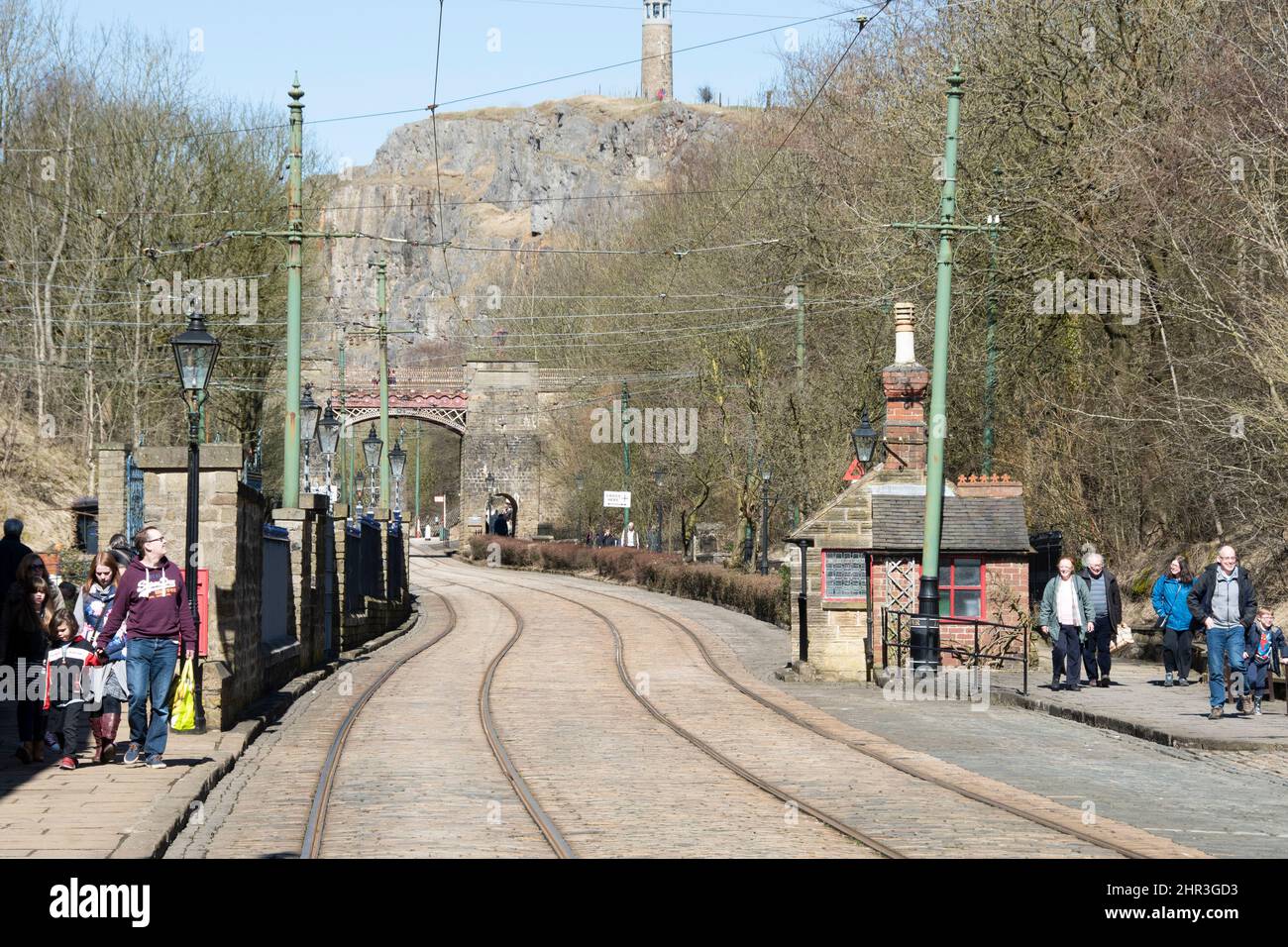 Derbyshire, UK – 5 April 2018: Families walk in the Spring sunshine beside the tram tracks of the Crich Tramway Village National Tram Museum Stock Photo