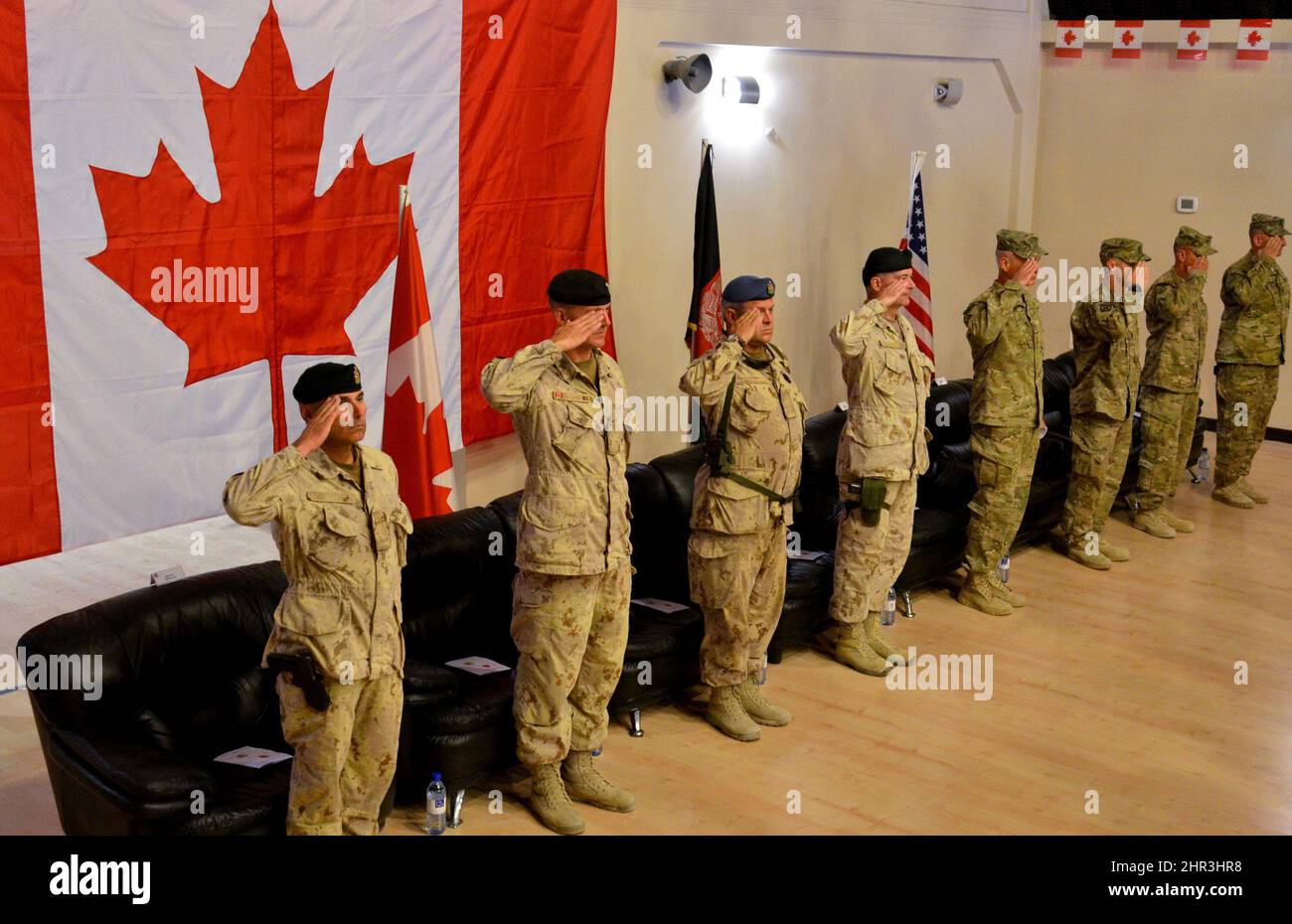 Canadian and American officers salute during the playing of the Canadian national anthem during a transfer of authority ceremony on Thursday, July 7, 2011. From the left: Chief Warrant Officer Gerald Blais, Brig.-Gen. Dean Milner, Chief Warrant Officer Jorma Â“HammyÂ” Hamalainen, Lt.-Gen. Marc Lessard, commander of Canadian Expeditionary Force, Maj.-Gen. James Terry, head of NATO Regional Command South, Command Sgt.-Maj. Christopher Greca, U.S. 10th Mountain Division, Col. Todd Wood, commander of the 1st Stryker Combat Team, 25th U.S. Infantry Division and Command Sgt.-Maj. Bernie Knight. The  Stock Photo