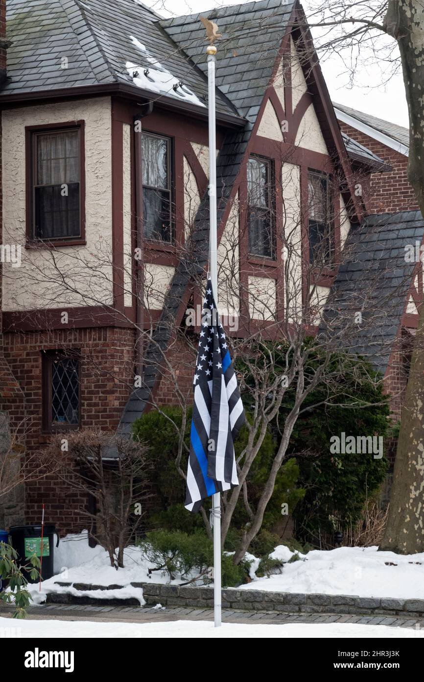 A Blue Line American Flag supporting the police hangs at half mast honoring fallen NYPD officers, Jason Rivera & Wilbert D. Mora. In Queens, New York. Stock Photo