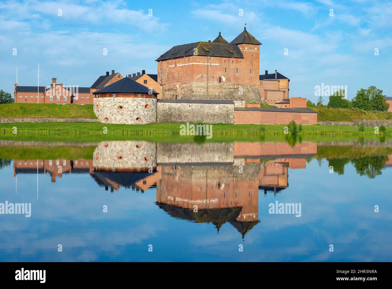 The ancient fortress of the city of Hameenlinna on the shore of Lake Vanayavesi with a reflection. Finland Stock Photo