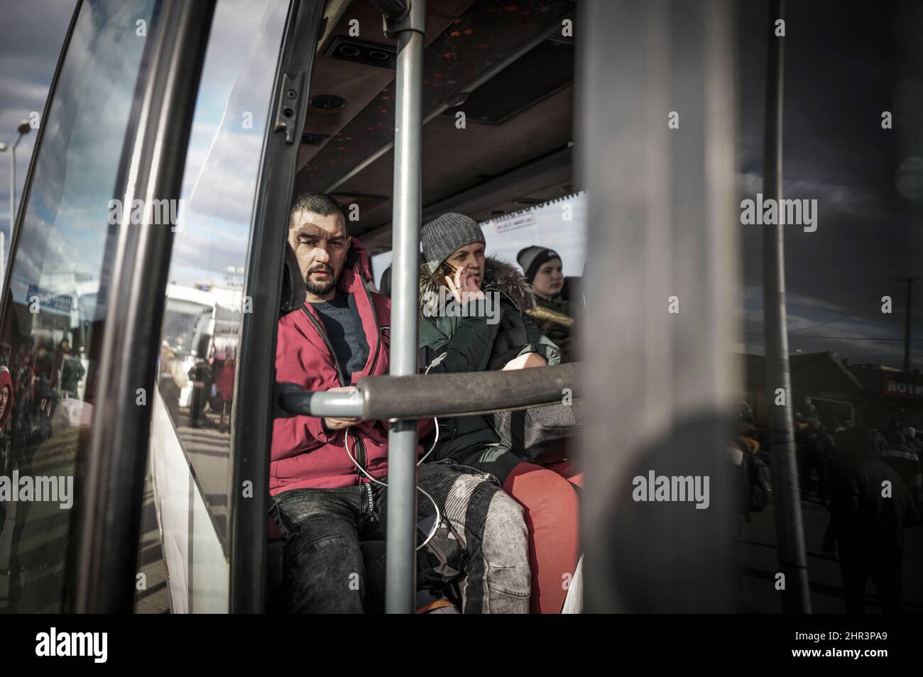Medyka, Poland. 25th Feb, 2022. Refugees from Ukraine sit on a bus taking them to a temporary shelter after crossing the border from Shehyni in Ukraine to Mecca in Poland. Many Ukrainians leave the country after military actions by Russia on Ukrainian territory. Credit: Michael Kappeler/dpa/Alamy Live News Stock Photo