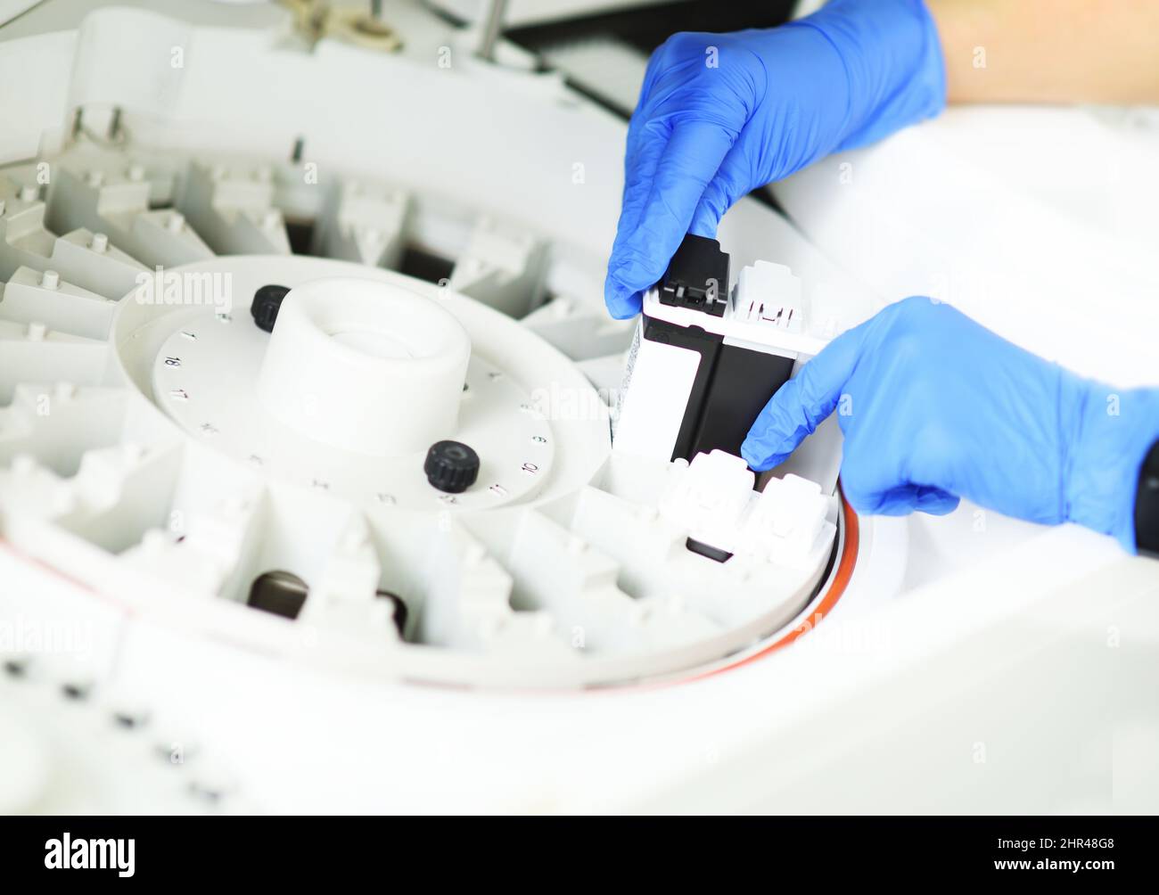 laboratory assistant in blue rubber gloves adds a reagent to the ...