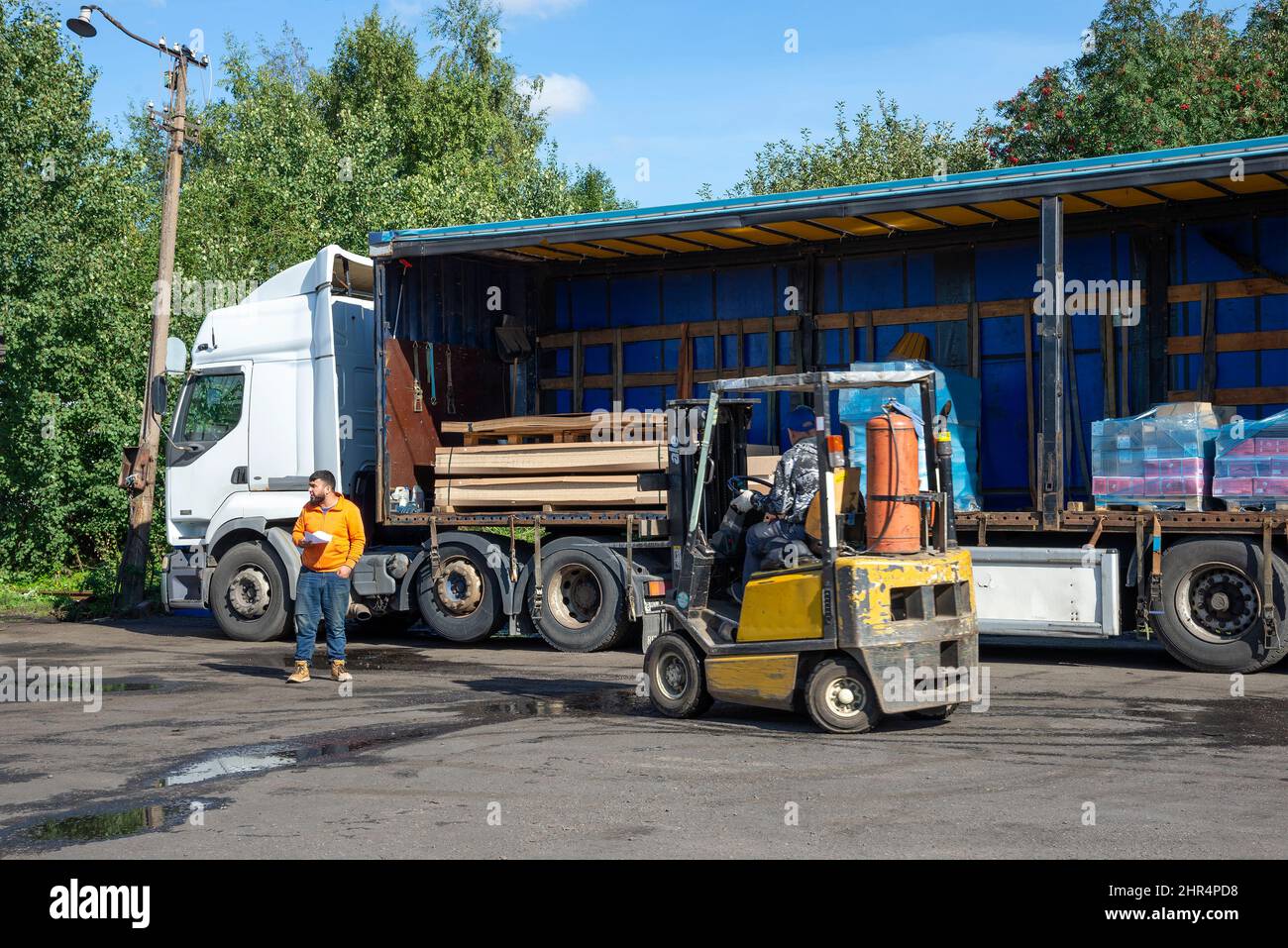 SAINT PETERSBURG, RUSSIA - SEPTEMBER 10, 2021: A forklift loads construction goods into a truck Stock Photo