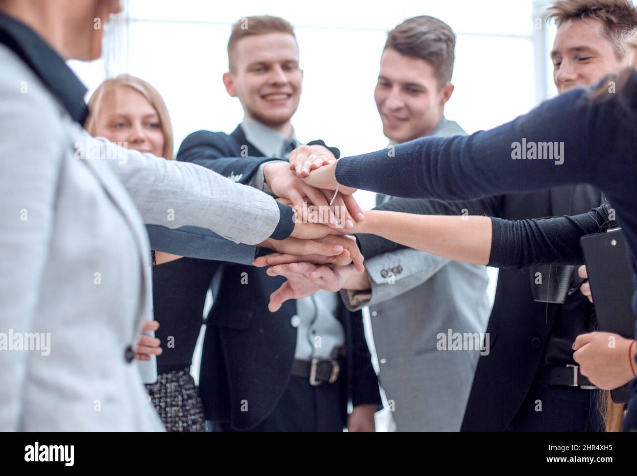 young employees making a stack out of their hands Stock Photo