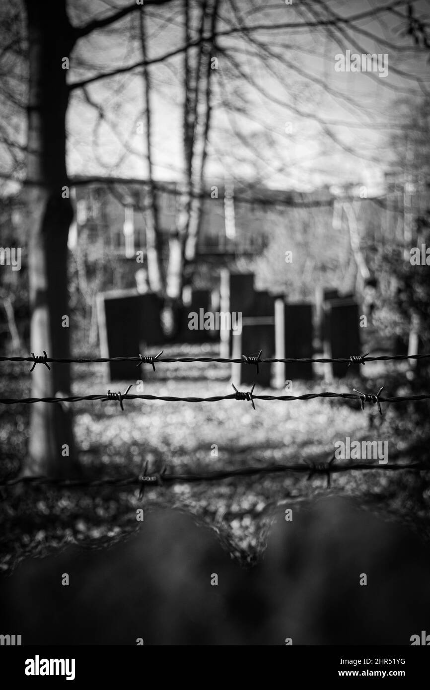 Vertical shot of the wire fences on a blurry background in black and ...
