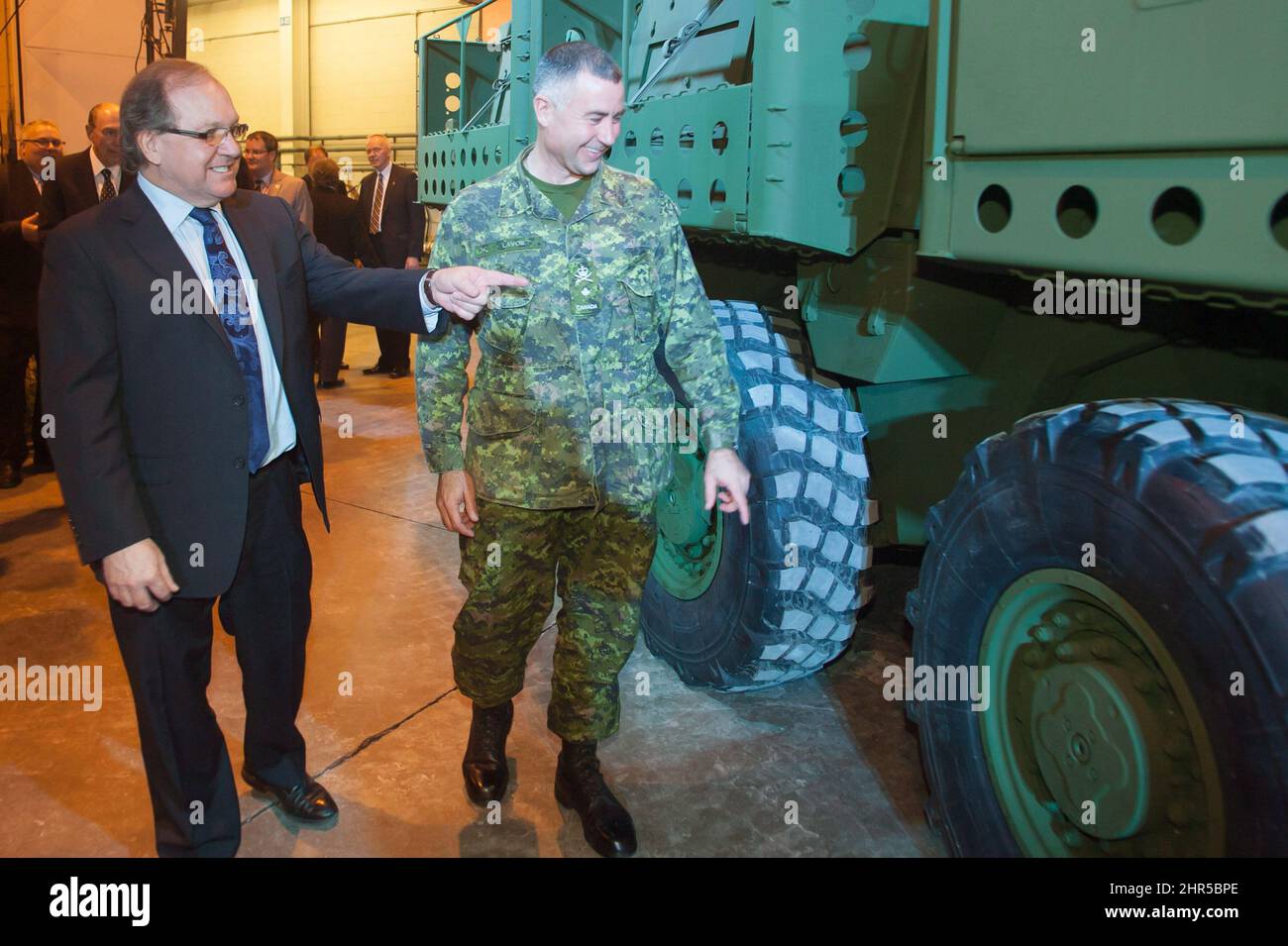 Bernard Valcourt, Associate Minister of National Defence, inspects the outside of the new upgraded Light Armoured Vehicle, along with Brigadier General Omer Lavoie, at a news conference for the unveiling of the new vehicle at a General Dynamics facility in London, Ont., on Thursday, January 24, 2012. THE CANADIAN PRESS/Mark Spowart Stock Photo