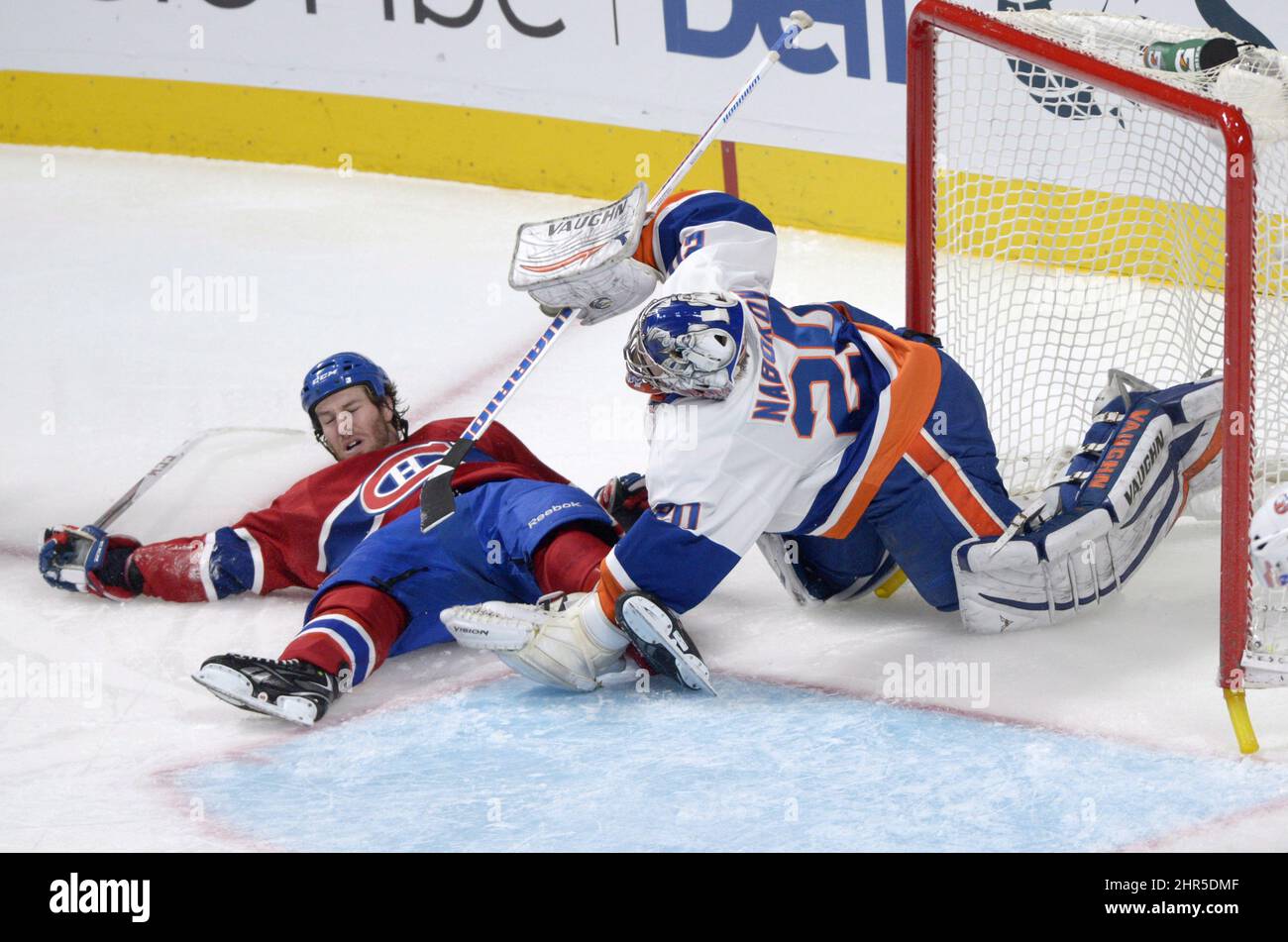 Montreal Canadiens' Brandon Prust, left, collides with New York Islanders goaltender Evgeni Nabokov during second period NHL hockey action in Montreal, Thursday, February 21, 2013. THE CANADIAN PRESS /Graham Hughes. Stock Photo