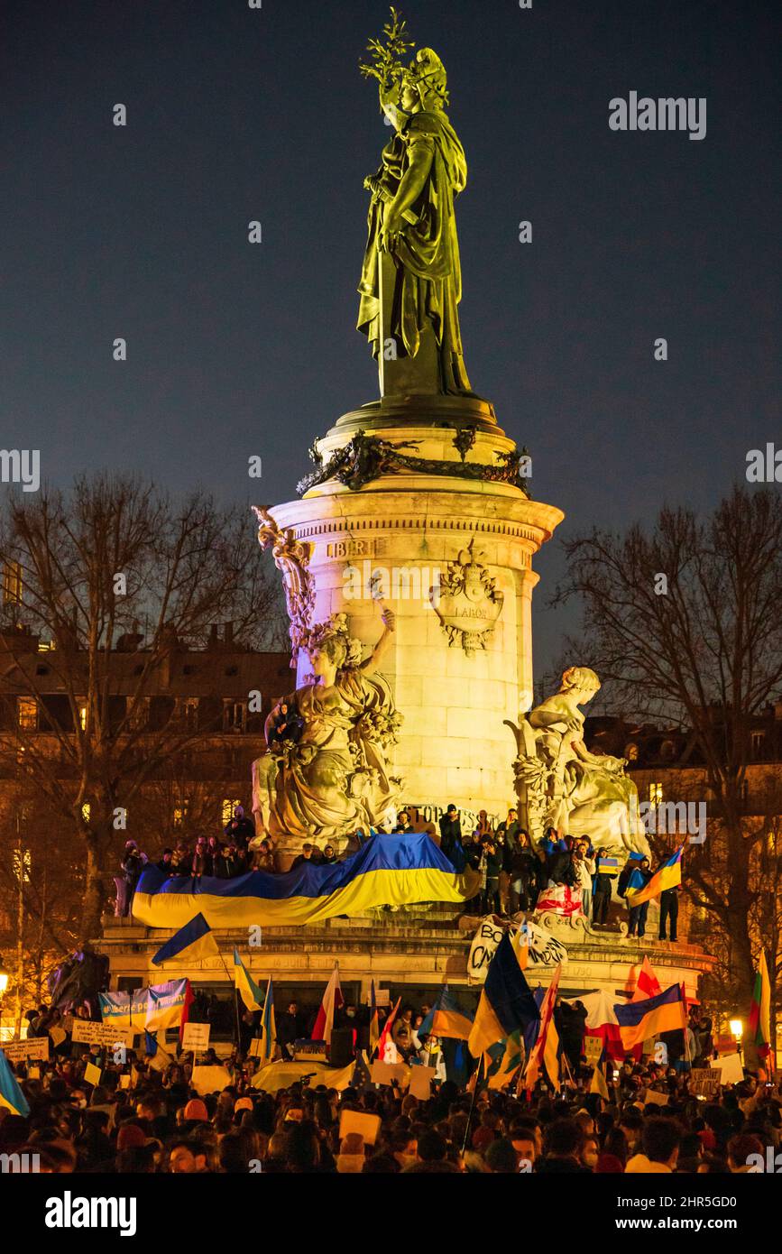 Paris, France. February 23 2022: People demonstrate at Place de la Republique against Putin's aggression and waving Ukrainian flags supporting Ukraine in Paris, France Stock Photo