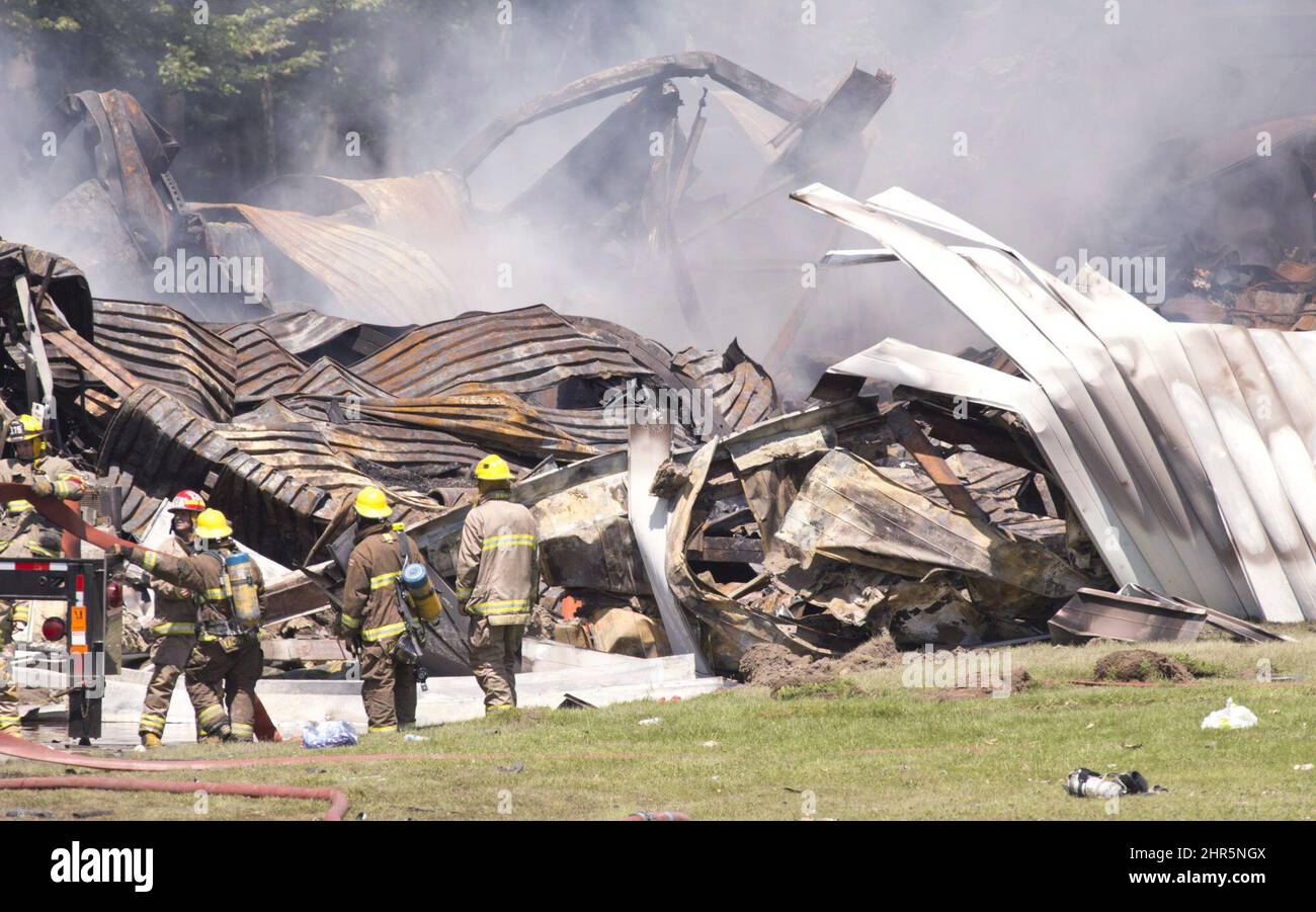 Firefighters clean up following an explosion at the B.E.M. fireworks